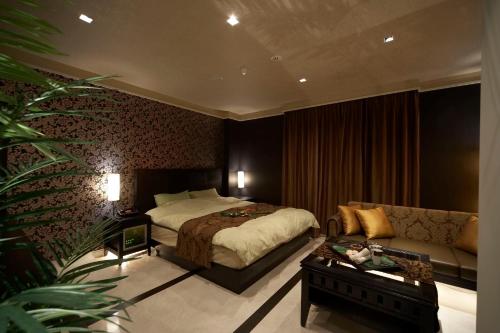 um quarto de hotel com uma cama e um sofá em Le Ciel Spa & Resort -Adlt only- em Tsurugashima