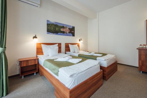 two beds in a hotel room with sidx sidx sidx sidx at Pensiunea Comfort in Sovata