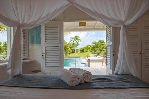 a bedroom with a bed with towels on it at Villa La Vanille à Marie Galante - vue mer & piscine in Grand-Bourg