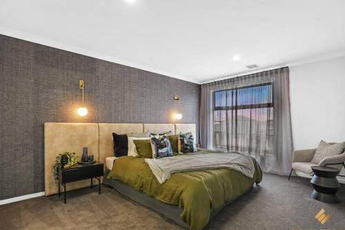 a bedroom with a large bed and a window at Brand New Modern 4 Bedroom Luxury Retreat in Caroline Springs