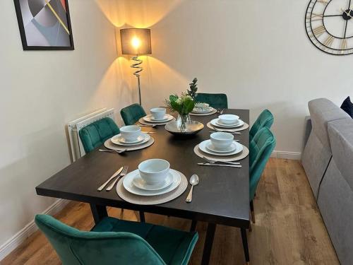 斯溫頓的住宿－Bilborough House - Comfy furnitures, Free Wifi and Free Parking，一间带桌子和绿色椅子的用餐室