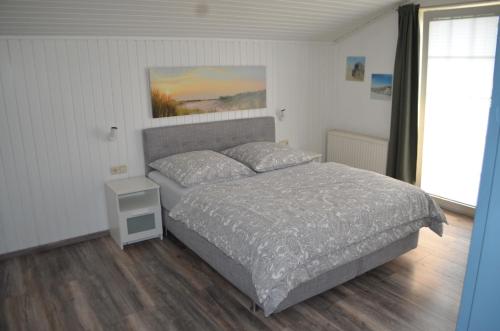 a bedroom with a bed in a room with a window at Schoner im Schiffehaus in Wangerland