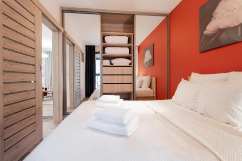 1 dormitorio con paredes rojas y 1 cama con almohadas blancas en Golden Apartments Warsaw - Big Apartment in Luxury Building near Metro Station-Grzybowska 85, en Varsovia