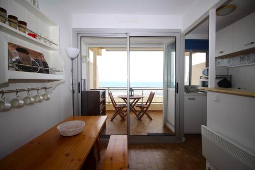une cuisine avec une table et une vue sur l'océan dans l'établissement Studio 3 personne VUE MER, à Canet