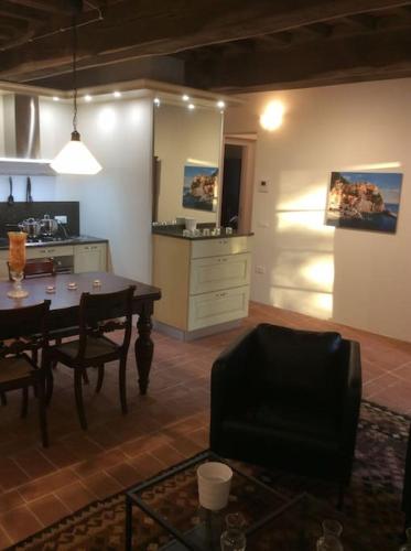 a living room with a table and a kitchen at Casa Lucchese al Borghetto in Collodi