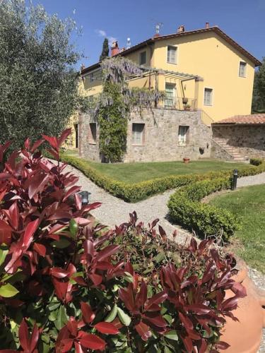 a large house in the back of a garden at Casa Lucchese al Borghetto in Collodi
