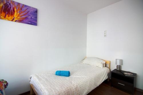 um pequeno quarto com uma cama e um quadro na parede em Apartament tuż za rogiem Zamku em Malbork