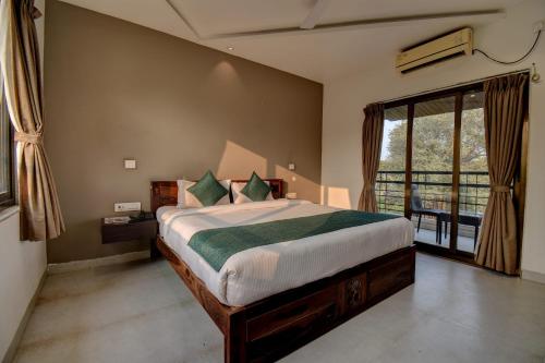 a bedroom with a bed and a large window at Peninsula Beach Resort in Calangute