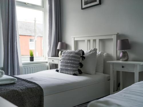a bedroom with a bed with a pillow and a window at East House - 3 bedroom- Stakeford, Northumberland in Hirst