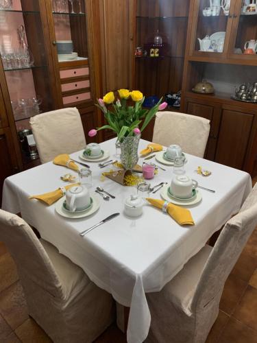 a table with a white table cloth and yellow flowers on it at Il giardino in Canicattì