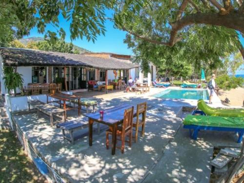 a pool with tables and chairs next to a house at Thumbi View Lodge in Cape Maclear
