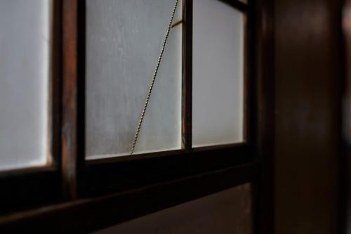 a close up of a glass window with a chain at Shirafuji in Suzaka