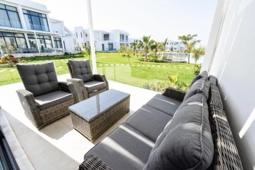 un patio con 2 sedie, un divano e un tavolo di The Resort Country Club & Spa a Akanthou