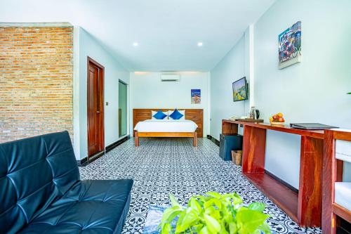 a bedroom with a bed and a couch in a room at Kampot Sweet Boutique in Kampot