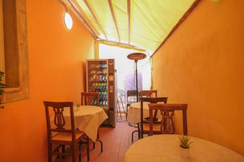 a restaurant with tables and chairs and a room with orange walls at San Tommaso in Pisa