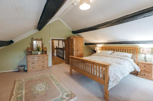 um quarto com uma cama de madeira e uma cómoda de madeira em Llanhedric House em Clun