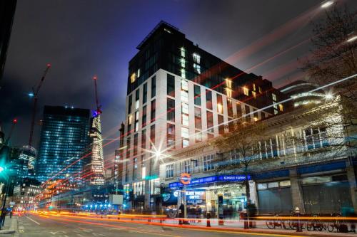 a city street at night with buildings and lights at Leonardo Hotel London Aldgate - formerly Hotel Saint in London