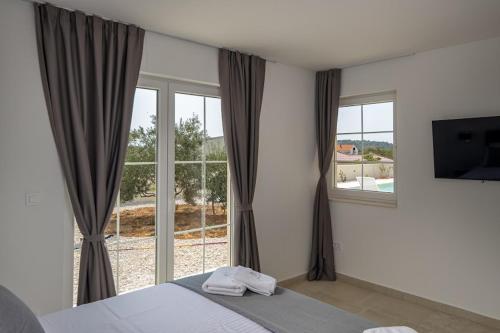 a bedroom with a bed and a large window at Villa Stina Jezera, Murter in Jezera