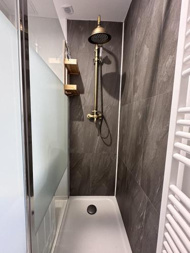 La salle de bains est pourvue d'une douche avec une lumière sur le mur. dans l'établissement Le Wabi-Sabi - T2 duplex - terrasse privée, à Vannes
