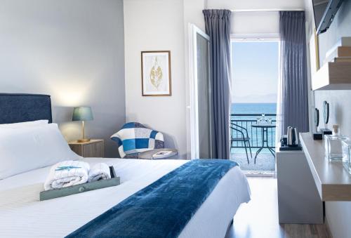 sypialnia z łóżkiem i widokiem na ocean w obiekcie RIVIERA HOTEL w mieście Xylokastron