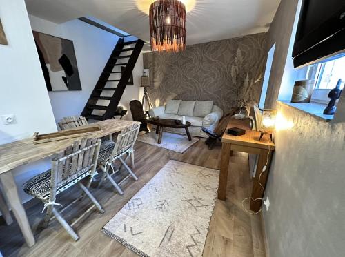 salon ze stołem, krzesłami i schodami w obiekcie Le Wabi-Sabi - T2 duplex - terrasse privée w mieście Vannes
