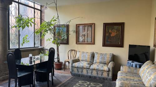 uma sala de estar com sofás, uma mesa e uma televisão em Vizi e Virtù em Ferrara