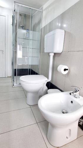 a white bathroom with a toilet and a sink at Guest Holiday Mandra 12 e 13 in Reggio Emilia