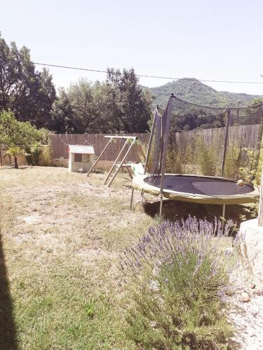 a backyard with a trampoline and a trampoline at Maison ensoleillée de plain-pied ouvert sur un jardin clôturé in Mallemoisson