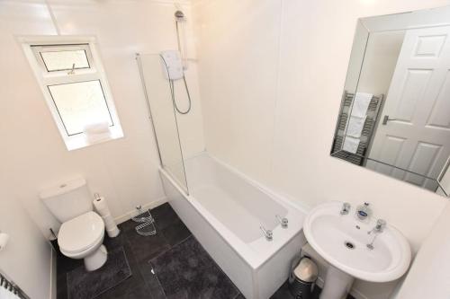 uma casa de banho branca com um WC e um lavatório em 3 Bedroom Apartment in a Quiet Location em Airdrie