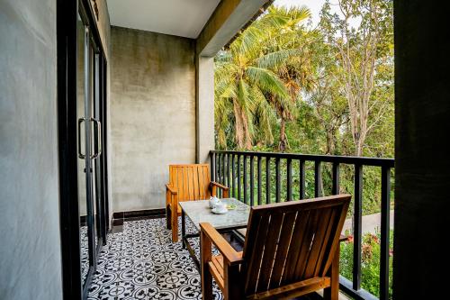 a porch with a table and chairs on a balcony at Kampot Sweet Boutique in Kampot