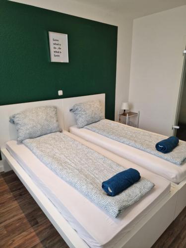 two beds in a room with blue pillows on them at Sky Night City Appartment in Düren - Eifel