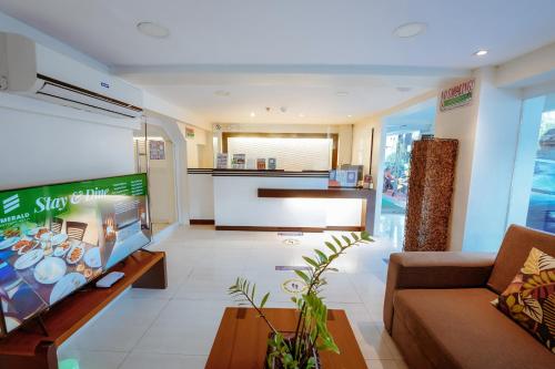 - un salon avec un canapé et une télévision dans l'établissement Emerald Boutique Hotel, à Legazpi