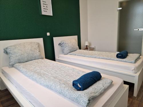 two beds in a room with a green wall at Sky Night City Appartment in Düren - Eifel