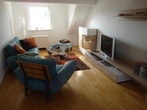 ein Wohnzimmer mit einem Sofa und einem TV in der Unterkunft Ferienwohnung Schlossblick in Reichelsheim