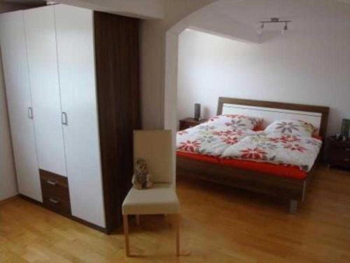 1 dormitorio con 1 cama y 1 silla en Ferienwohnung Schlossblick, en Reichelsheim