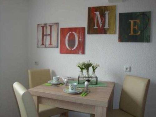 una mesa de comedor y sillas con una mesa de madera y algunas pinturas en Ferienwohnung Schlossblick, en Reichelsheim