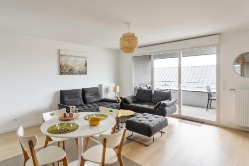 un salon avec un canapé, une table et des chaises dans l'établissement Le Rochenoire - Appt proche plage, à Dinard