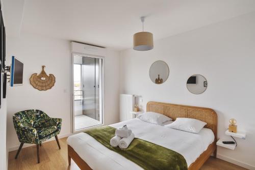 sypialnia z łóżkiem, krzesłem i oknem w obiekcie Le Rochenoire - Appt proche plage w mieście Dinard