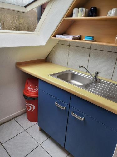 a small kitchen with a sink and a trash can at Monteurunterkunft Licherode 
