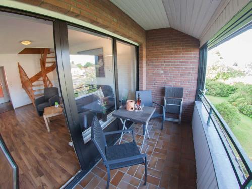 a balcony of a house with a table and chairs at Ferienwohnung Nordseeluft, FeWo Vermittlung Nordsee in Dangast