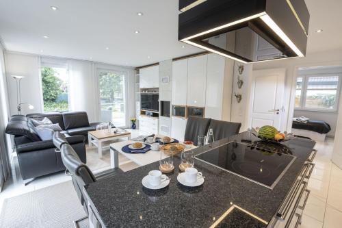 a kitchen and living room with a table and chairs at Ferienwohnung Rudi s Huus, FeWo Vermittlung Nordsee in Langendamm