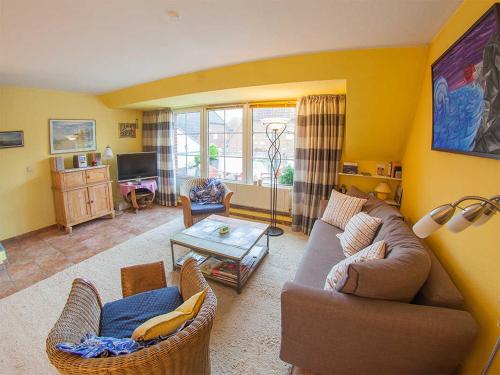 un salon avec un canapé, des chaises et une table dans l'établissement Ferienwohnung Sonnenkoje, FeWo Vermittlung Nordsee, à Dangast
