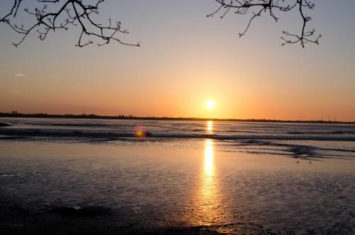 - un coucher de soleil sur la plage dans l'établissement Ferienwohnung Sonnenkoje, FeWo Vermittlung Nordsee, à Dangast