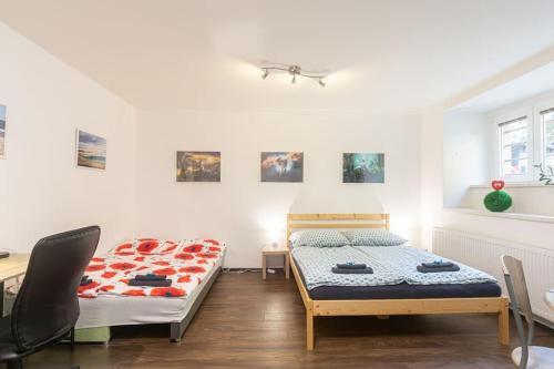 two beds in a room with a desk and chairs at Cozy basement flat, SkyShowtime, 3 minutes to center in Prague