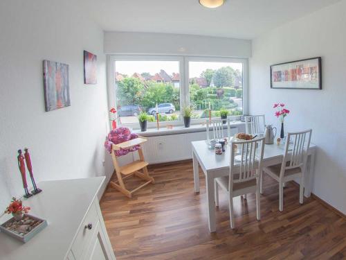 a kitchen and dining room with a table and chairs at Ferienwohnung Nordseeluft, FeWo Vermittlung Nordsee in Dangast
