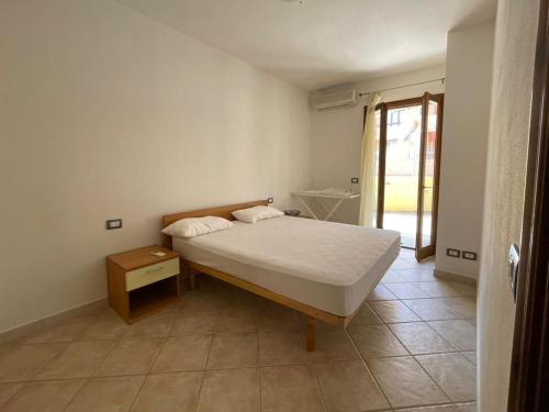 una camera con letto, tavolo e finestra di Residence La Spiga a Castelsardo
