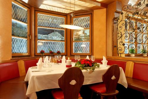 - une salle à manger avec une table, des chaises et des fenêtres dans l'établissement Wo der Hahn kräht, à Flein