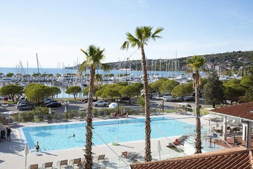 a large swimming pool with palm trees in a marina at Stella blue Floating House Portorož in Portorož