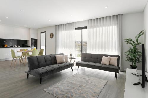 a living room with two couches and a kitchen at Consolação Blue Paradise in Consolação