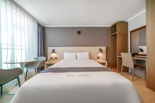 a hotel room with a large bed and a desk at Gyeongpo Soo Hotel in Gangneung
